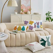 Load image into Gallery viewer, Decorative pillows with colorful animal patterns on a beige sofa in a living room. Spring Melody Embroidered Cushion Covers by Allthingscurated feature charming seasonal details to transition your home into Spring and Easter effortlessly. Each cover showcases meticulous embroidery to add depth and visual interest to your sofa and furniture.
