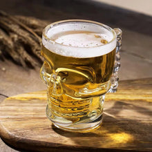Load image into Gallery viewer, Skull Beer Mug by Allthingscurated blends functionality with style. Made with thickened glass with a heavy bottom for stability, it spots a fun, cool skull shape design that is ideal for Halloween or everyday use. The large capacity is perfect for beer or any beverage. Add this must-have mug to your drinkware collection and be ready for any gatherings or house parties.
