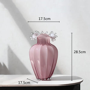 Anais Pink Beaded Vases by Allthingscurated are crafted from handblown glasses. Featuring a curvaceous body with an asymmetrical beaded rim that flares back like a collar.  Its captivating shape and romantic pink hue makes it a statement piece and a glamorous addition to your vase collection. Featured here is a small size measuring 28.5cm or 11 inches in height and 17.5cm or 6.8 inches in width.