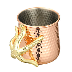 This one-of-a-kind Starfish Copper-plated Mug by Allthingscurated is more than just interesting. Featuring a playful design and a striking starfish handle for a secure grip, it makes a charming conversation piece at your next gathering. Crafted from stainless steel and copper-plated for the exterior, it will keep your cold beverage icy and refreshing. Has a capacity of 540ml or 18 ounce. A great gift idea for anyone who likes a little whimsy and playfulness while enjoying their favorite drink.