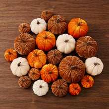 Load image into Gallery viewer, A collection of small decorative velvet pumpkins in orange, brown, and cream, arranged on a dark brown wooden surface.
