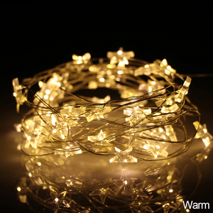 Mini Stars LED Fairy Lights by Althingscurated. Create a cozy and festive atmosphere with these decorative lights that offer a warm, tinkling glow. These mini stars are attached to silver wire that is bendable and easy to manipulate so you can fit them into tiny spaces or wrap around objects to enhance your favorite decorations.  Comes in 6 different lengths from 1 meters to 6 meters or 39 to 236 inches. Available in warm white or white lights. Featured here is warm white light.