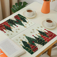 Load image into Gallery viewer, Decorative placemats with Christmas tree design on a table with cups and a book.
