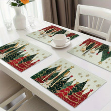 Load image into Gallery viewer, Dining table set with Christmas-themed placemats, cups, and cutlery.
