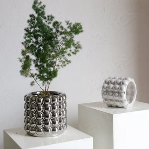 Zayla Bubble Planters by Allthingscurated are made from ceramic. These planters feature a chic design with striking 3D bubble exterior that looks sophisticated and will transform the look of your beloved indoor plants effortlessly. Come in 2 sizes and available in 3 colors that will complement any modern home décor styles.