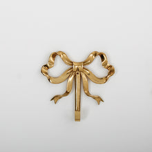 Load image into Gallery viewer, These pretty wall hooks by Allthingscurated are made of high-quality brass with a vintage gold finish.  Fashioned like a bow tied with ribbon, it’s feminine and perfect for the walk-in wardrobe or powder room. Comes in small and large size. Small hook measures 7.3cm or 2.8 inches in height and 6.5cm or 2.5 inches in width. Large hook measures 10.3cm or 4 inches in height and 9.5cm or 3.7 inches in width. Sold as individual hooks or a set of small and large hooks. This is a large hook.
