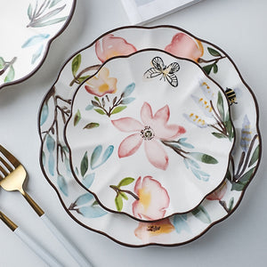 Allthingscurated’s Camille dinnerware features hand-painted florals, fauna and pretty butterflies and a color scheme of pink, yellow, blue,green and brown against a white ceramic background. Every plate is designed with a brown-lined scallop edge. Available in 6, 8 and 10 inches or 15.5, 20 and 25.5cm.