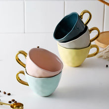 Load image into Gallery viewer, Allthingscurated colorful glazed porcelain cups with gold handle. Designed with a slight all-over concave effect surface that is unique. Available in pink, green, gray, yellow and teal with a capacity of 360ml or 12 ounce.
