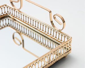 Donatella mirror tray by Allthingscurated showing off its gold-gilded handle and intricate patterns framing the tray with gleaming mirror surface.