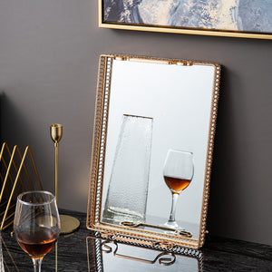 Donatella Mirror tray by Allthingscurated features a mirror surface and intricate gold-gilded pattern surround all sides of the rectangle tray and with 2 handles. Available in small, medium and large size. Featured here is a large rectangle tray leaning agains the wall. The surface of the tray can eve become a mirror on its own.