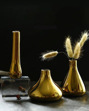 Load image into Gallery viewer, 3 gold mini vases shot against a dark black background.
