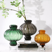 Load image into Gallery viewer, Luna Lantern Vases by Allthingscurated are stylish and versatile. Crafted from high-quality thick glass and creatively shaped like an Oriental Lantern with a strong aesthetic, they are perfect for creative floral arrangement or simply as a decorative display on its own. Comes in 2 sizes and 3 avaliable colors of green, gray and amber.
