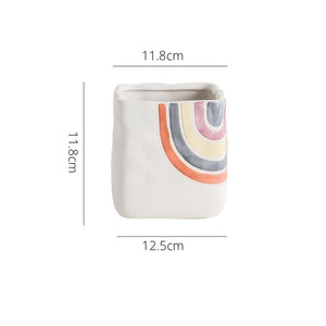 Biba Ceramic Square Planter by Allthingscurated features hand-painted rainbow-like pattern on a creamy white background with a groovy and hippie vibe. Available in small, medium and large size. This is a medium pot measuring 11.8cm by 11.8cm or 4.6 inches by 4.6 inches.