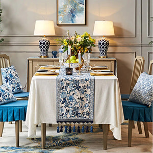 Porcelain Blue Table Runner by Allthingscurated features detailed designs of florals and birds in blue and printed on white background, inspired by the ancient Chinese Porcelain.  A fusion of the east and west— this CHINOISERIE style is contemporary, CHARMING and TIMELESS.  We added generous tassels in two shades of blues for a striking contrast. Made of cotton-linen blend with 6 sizes available.