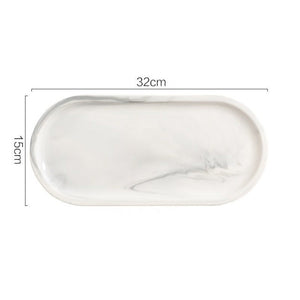 Allthingscurated Marble Design Oval Ceramic Trays in White with subtle marble veining. These trays can be used for serving and decorative purposes. Available in Small and Large size. This large tray measures 32 by 15 centimeters or 12.5 by 5.9 inches.