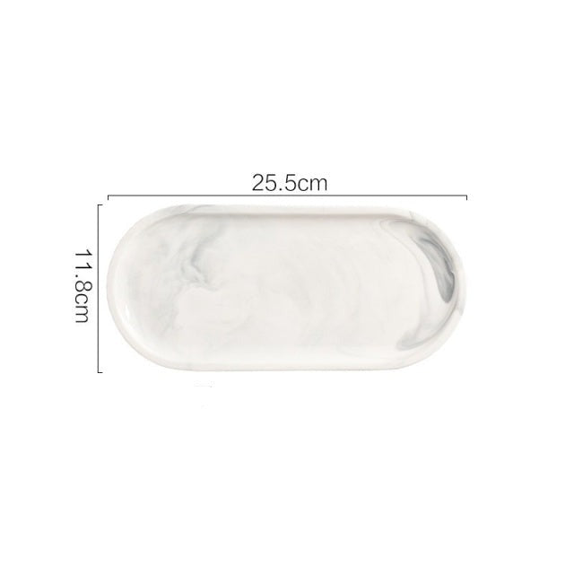 Allthingscurated Marble Design Oval Ceramic Trays in White with subtle marble veining. These trays can be used for serving and decorative purposes. Available in Small and Large size. This small tray measures 25.5 by 11.8 centimeters or 10 by 4.6 inches.
