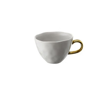 Load image into Gallery viewer, Allthingscurated glazed porcelain cup with gold handle in light gray.  Designed with a slight all-over concave effect surface that is unique. Has a capacity of 360ml or 12 ounce.
