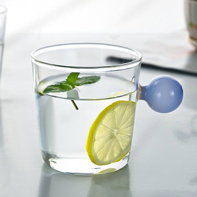 Drinking Glass with colored spherical handle in light blue, measuring 8.5 x 8.5 x 7cm or 3.3 x 3.3 x 3 inches with a capacity of 350ml or 11.8 ounce.