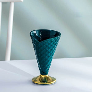 Allthingscurated dessert cup in the shape of an ice cream cone, measuring height 15.2cm and diameter 9.4cm. Made of glazed porcelain in dark green.